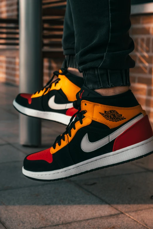 a person standing on a sidewalk wearing sneakers, a cartoon, trending on unsplash, hyperrealism, black and yellow and red scheme, “air jordan 1, dark oranges reds and yellows, standing on a desk