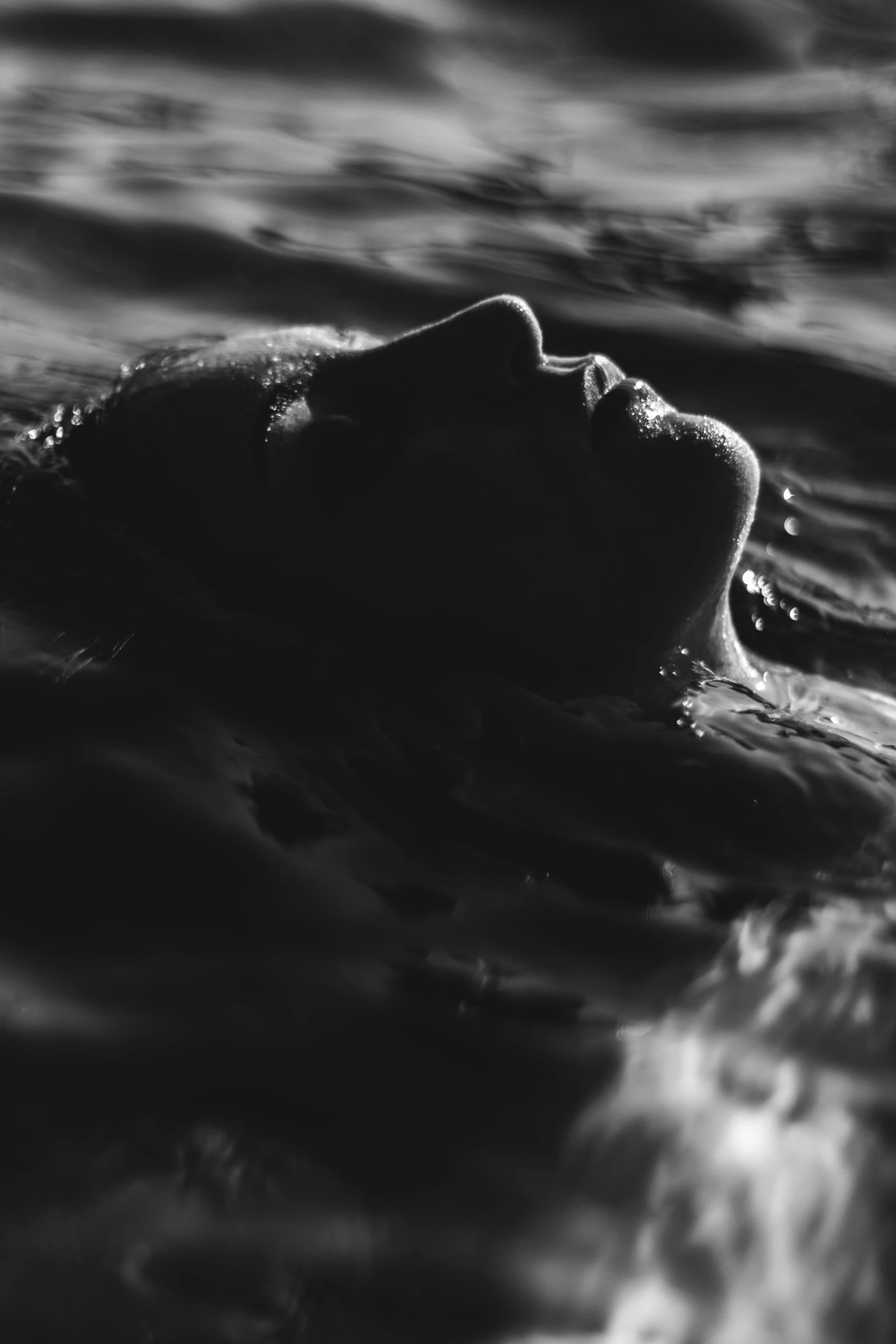 a woman floating on top of a body of water, a black and white photo, inspired by Max Dupain, unsplash, ffffound, close face view, summer night, flood