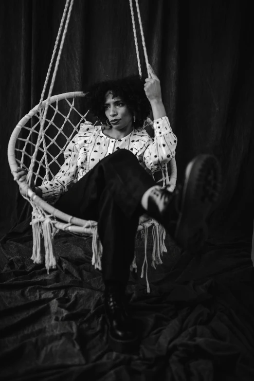 a black and white photo of a woman sitting in a hanging chair, inspired by Billie Waters, zoë kravitz, trippie redd, beautiful androgynous prince, beautiful boy