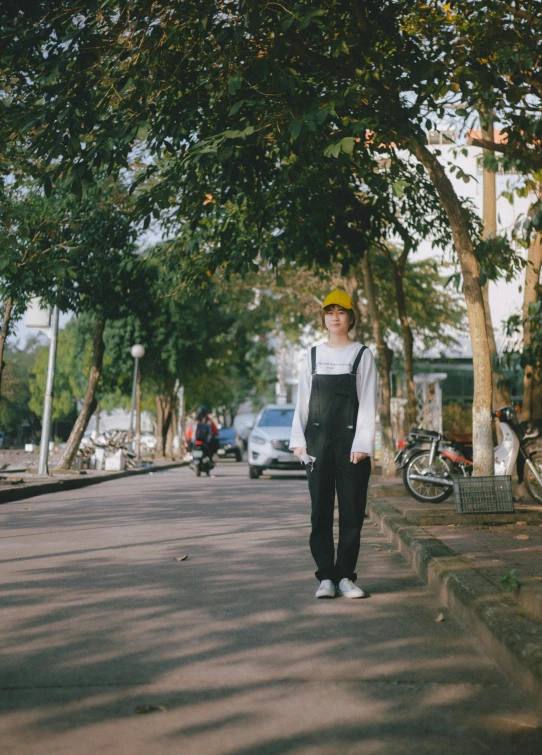 a woman in overalls is walking down the street, inspired by Cheng Jiasui, unsplash, wearing skate helmet, boyish, mono-yellow, [ cinematic