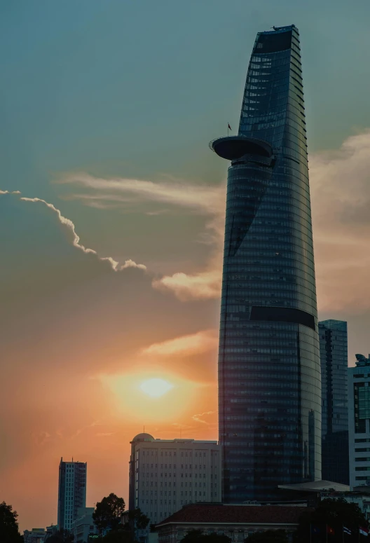 a very tall building sitting in the middle of a city, vietnam, profile image, sun setting, möbius