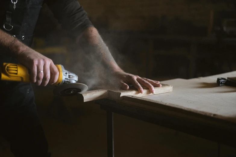 a man sanding a piece of wood with a power drill, by Matthias Stom, pexels contest winner, flour dust spray, wooden tables, curvy build, thumbnail