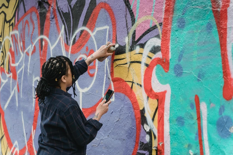 a woman is painting graffiti on a wall, by artist, pexels contest winner, checking her phone, 2 0 2 2 photo, essence, thumbnail