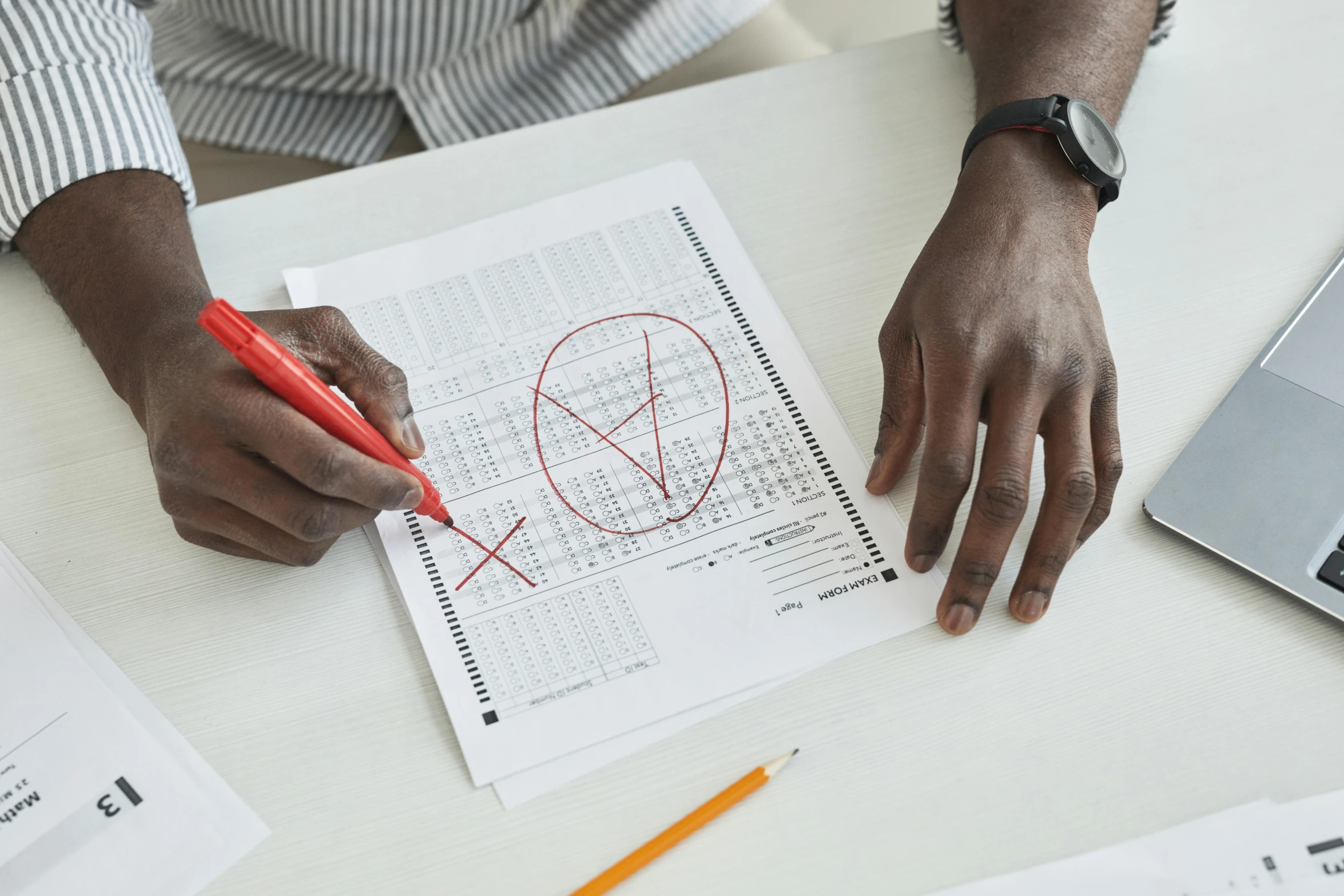 a man sitting at a desk writing on a piece of paper, an album cover, pexels contest winner, academic art, rule of thirds golden ratio, pencil drawing of mkbhd, summoning terrible odds, red writing