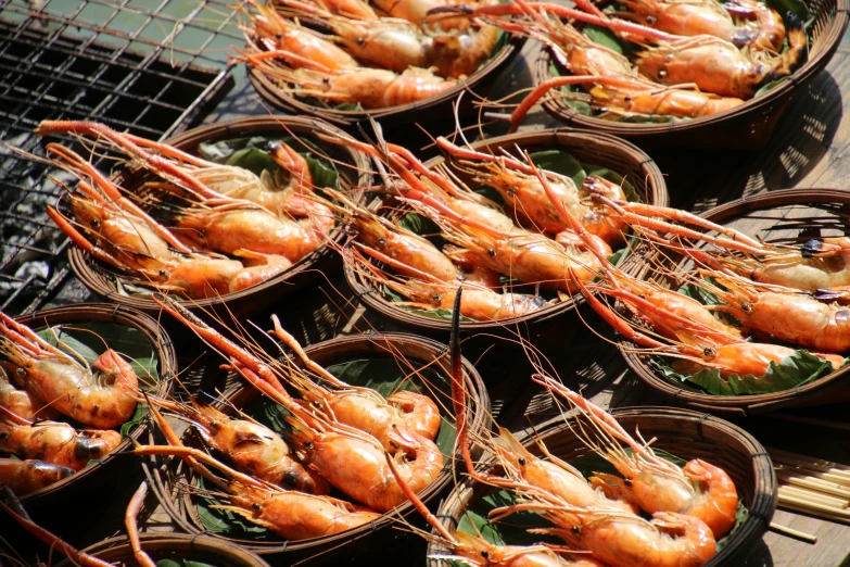 several baskets filled with shrimp sitting on top of a table, sōsaku hanga, bangkok, al fresco, avatar image