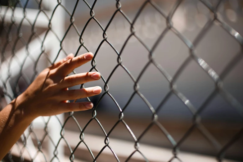 a hand reaching through a chain link fence, trending on pexels, hurufiyya, queen in a glass prison, schools, migrant mother, thumbnail