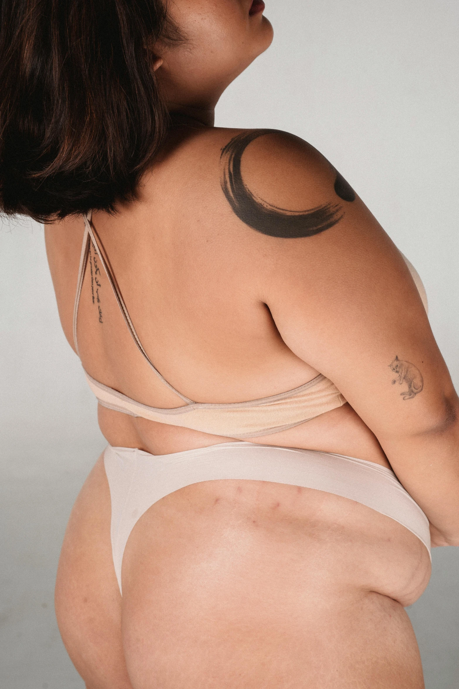 a woman with a tattoo on her back, inverted triangle body type, silicone skin, thick line ink, plus size