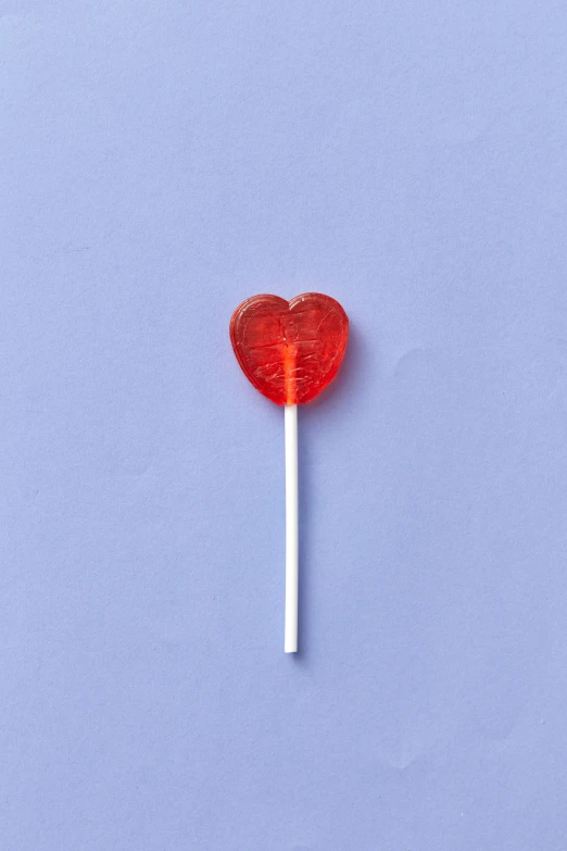 a red heart shaped lollipop on a stick, jen atkin, high resolution product photo, small, 1