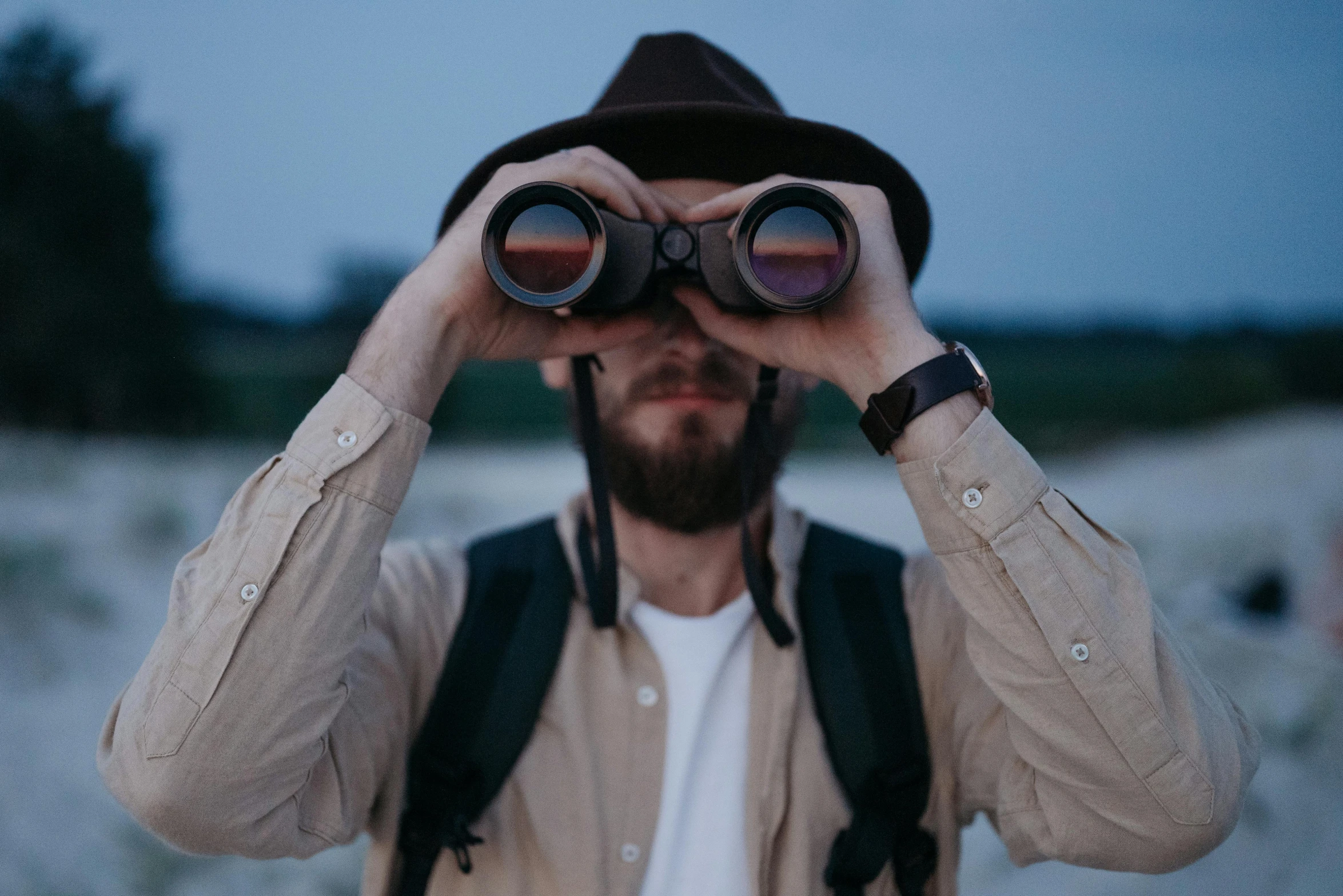 a man looking through a pair of binoculars, trending on pexels, hipster dad, looking straight ahead, explorers, bird sight