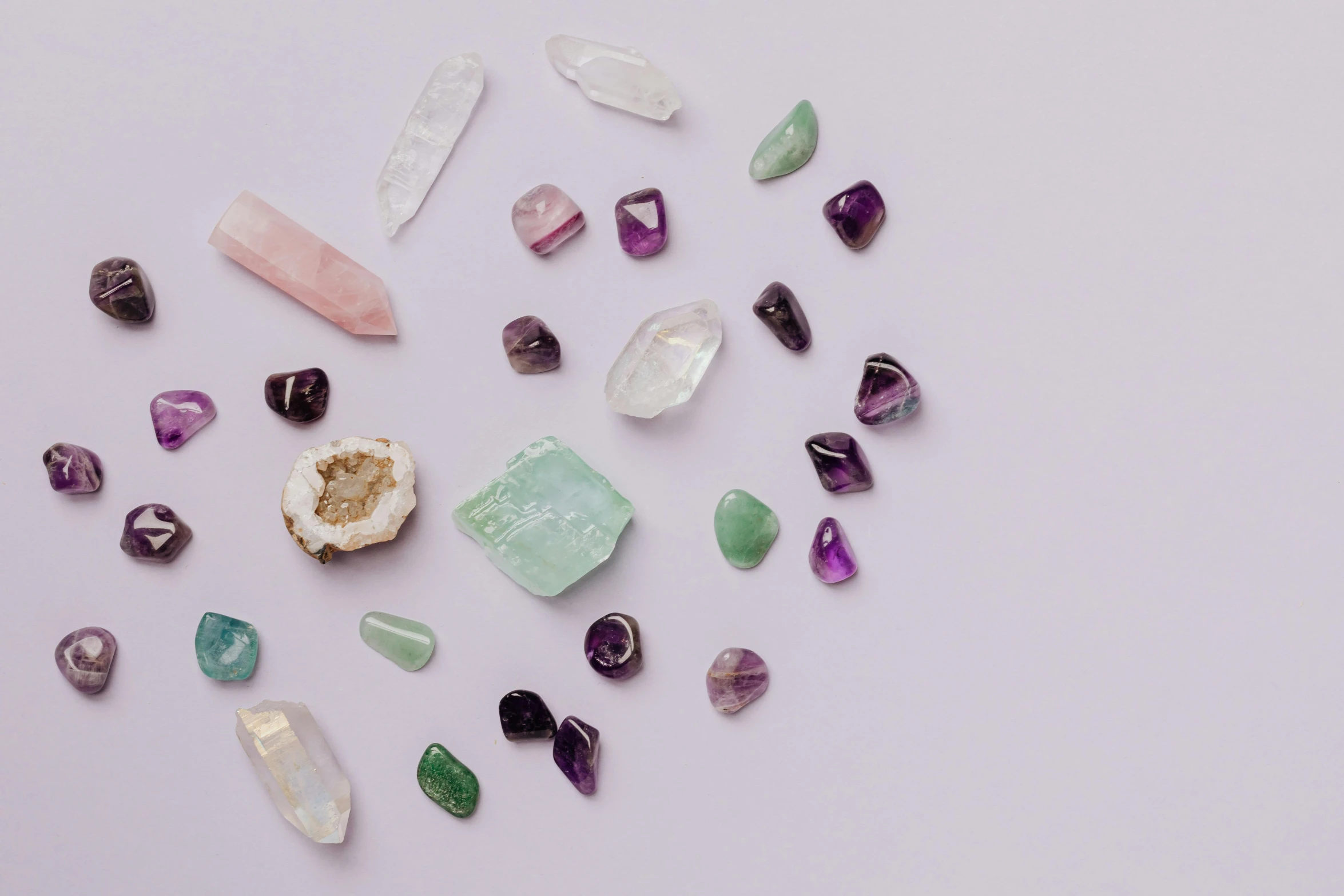 a bunch of different colored crystals on a white surface, trending on pexels, pastel purple background, emerald artifacts, ((rocks)), detailed product image