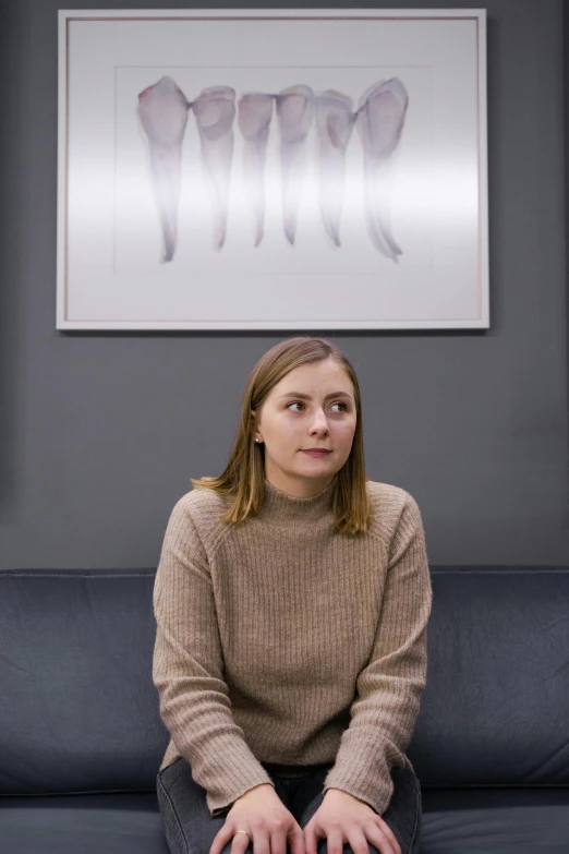 a woman sitting on a couch in a room, inspired by Sarah Lucas, trending on reddit, hyperrealism, film still from the office, mid length portrait photograph, elizabeth olsen, professional profile photo