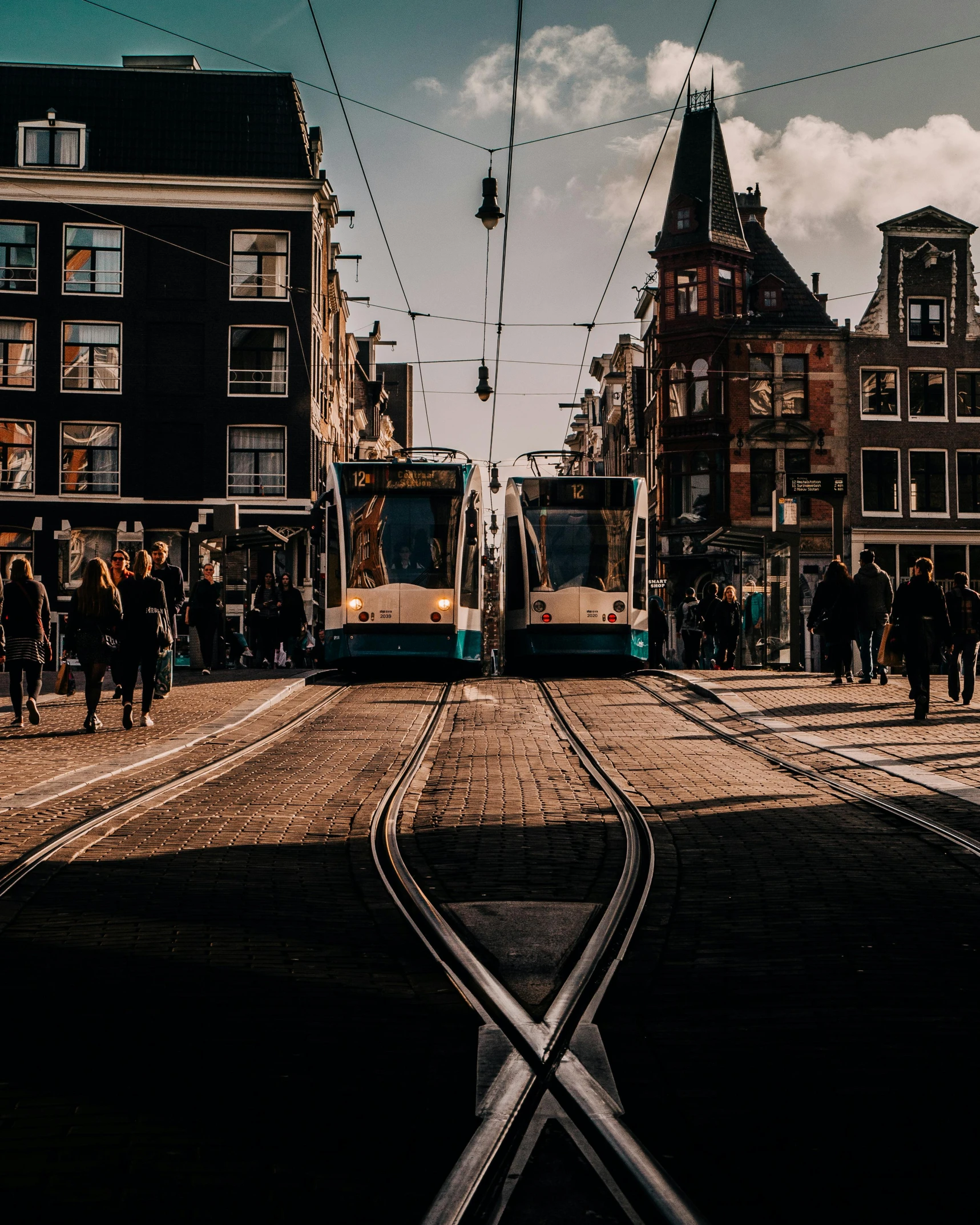 a train traveling down a city street next to tall buildings, by Jan Tengnagel, pexels contest winner, happening, delft, thick cables on ground, 🚿🗝📝, thumbnail