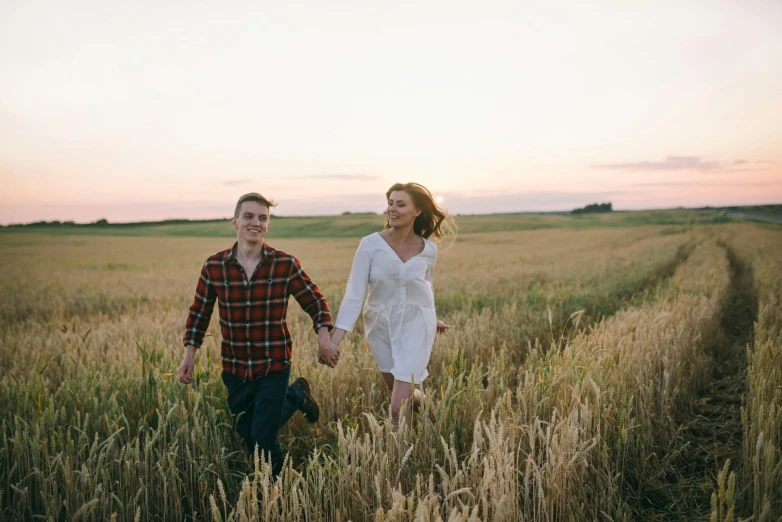 a man and woman walking through a wheat field, by Jessie Algie, pexels contest winner, attractive girl, lachlan bailey, early evening, smiling couple