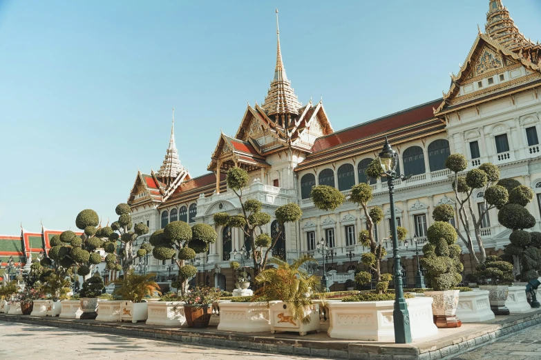 a row of potted plants in front of a building, ornate palace made of green, thai architecture, highly upvoted, square