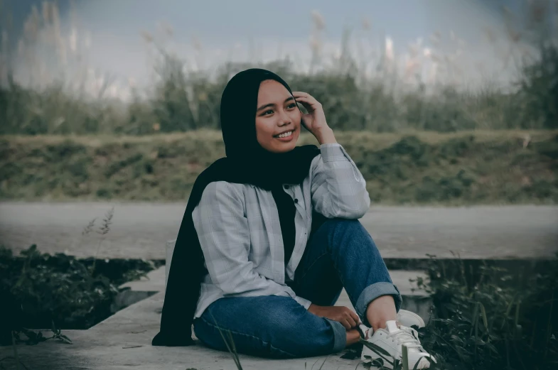 a woman sitting on the ground talking on a cell phone, inspired by Nazmi Ziya Güran, pexels contest winner, hurufiyya, confident relaxed pose, avatar image, modest, casual pose
