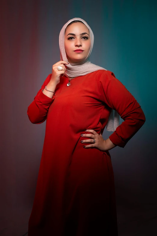 a woman in a red dress posing for a picture, inspired by Maryam Hashemi, hurufiyya, teal silver red, plain background, taken with sony alpha 9, ((portrait))