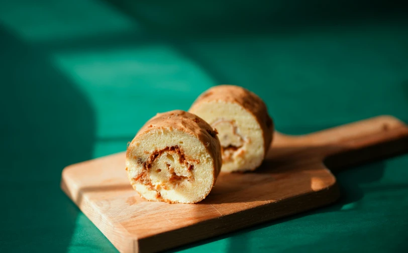 a piece of bread sitting on top of a cutting board, profile image, in the shape of a cinnamon roll, 千 葉 雄 大, product image