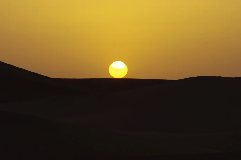 the sun is setting in the middle of the desert, inspired by Frederick Goodall, minimalism, colour photograph, moroccan, yellow, medium-shot