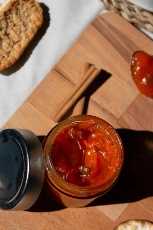 a jar of jam sitting on top of a wooden cutting board, by Julia Pishtar, renaissance, an island made of red caviar, thumbnail, detail shot, suns