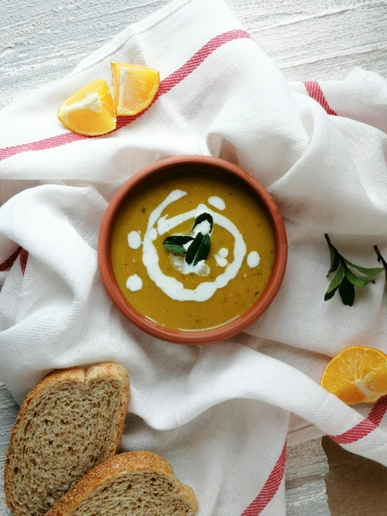 a bowl of soup next to slices of bread, inspired by Géza Dósa, unsplash, yellow and olive color scheme, white and orange, square, thumbnail