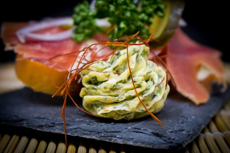 a close up of a plate of food on a table, by Matthias Stom, unsplash, art nouveau, melted cheddar, green eggs and ham, spiralling, slate