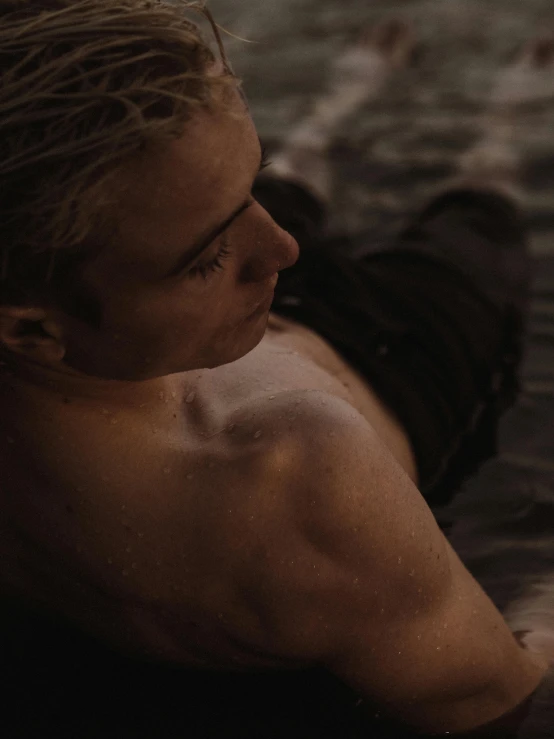 a man laying on top of a body of water, inspired by Elsa Bleda, unsplash contest winner, romanticism, blond boy, profile shot, film still from movie dune-2021, mid-shot of a hunky