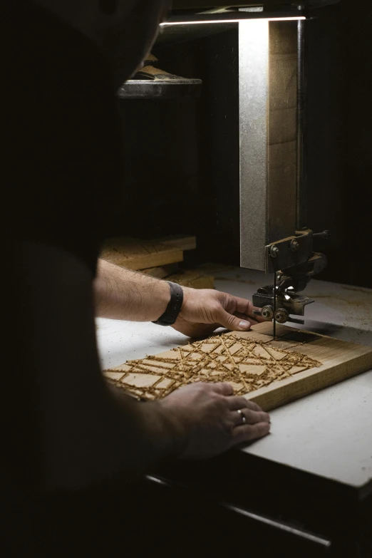 a man is working on a piece of wood, an engraving, inspired by Lubin Baugin, kinetic art, snacks, ignant, tabletop game board, studio lit