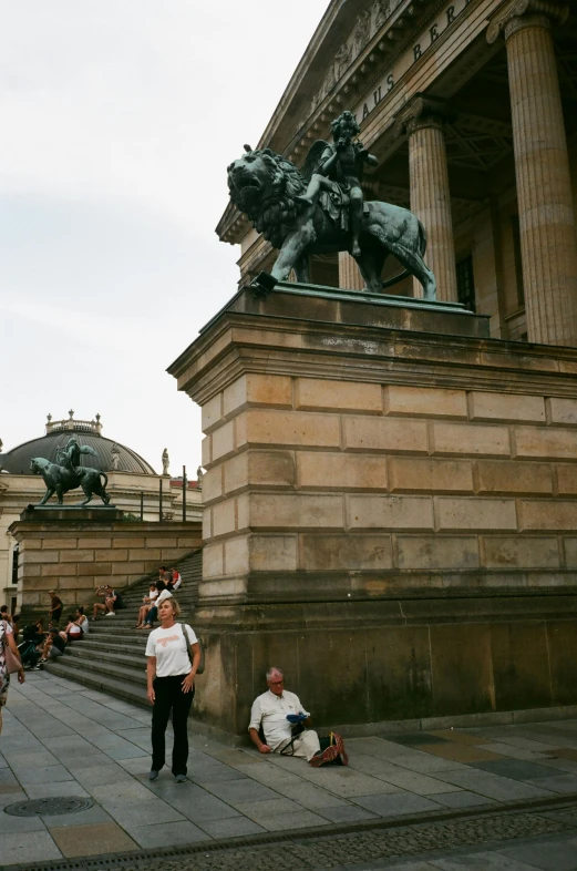 a group of people sitting on the steps of a building, a statue, inspired by Cornelis Engebrechtsz, neoclassicism, horse on top, statue of angela merkel, slightly tanned, giant columns