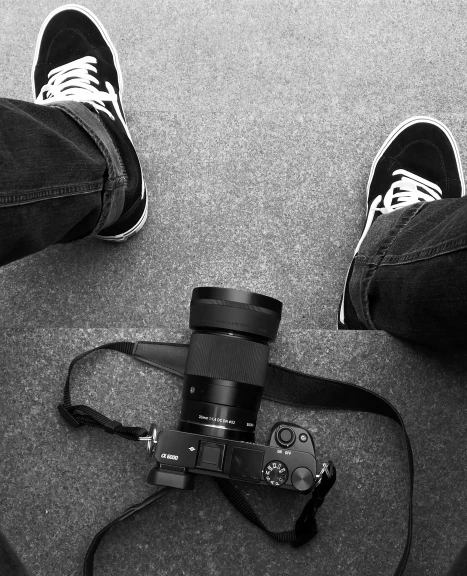 a black and white photo of a person with a camera, sneaker photo, sony a7, a high angle shot, ansel ]