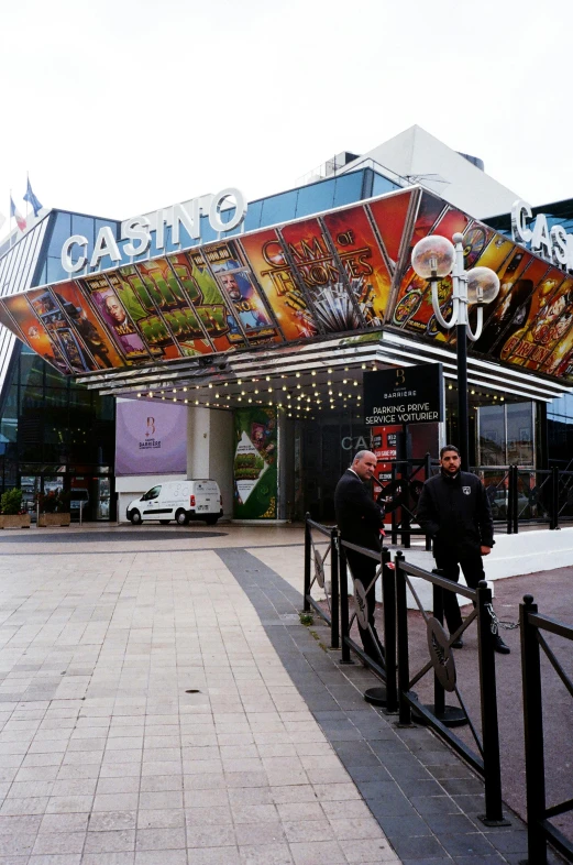 a group of people standing in front of a building, casino, rennes - le - chateau, let's play, entrance