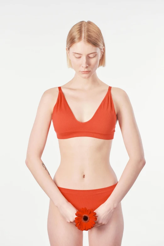 a woman in an orange bikini holding a flower, a colorized photo, inspired by Tang Di, cropped red yoga short, designed for cozy aesthetics!, wearing v - neck top, kano)