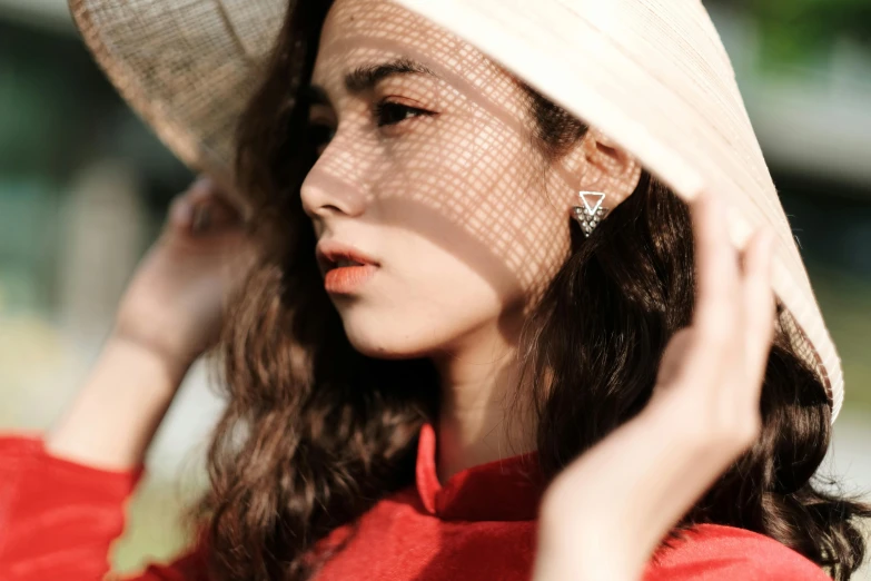 a woman in a red dress and a white hat, a picture, trending on pexels, earring, young asian girl, sun drenched, triangle makeup