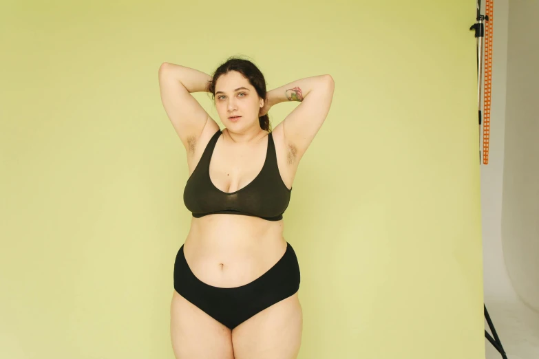 a woman in a black bikini posing for a picture, inspired by Esaias Boursse, trending on pexels, green colored skin, obese ), aged 2 5, underwear ad