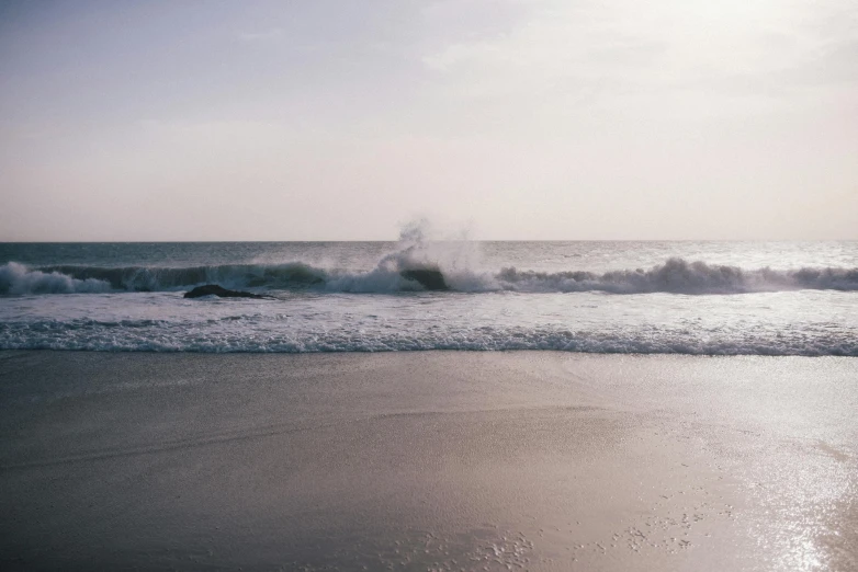 a man riding a wave on top of a sandy beach, unsplash contest winner, minimalism, purple sand, hazy water, ignant, large waves crashing over it