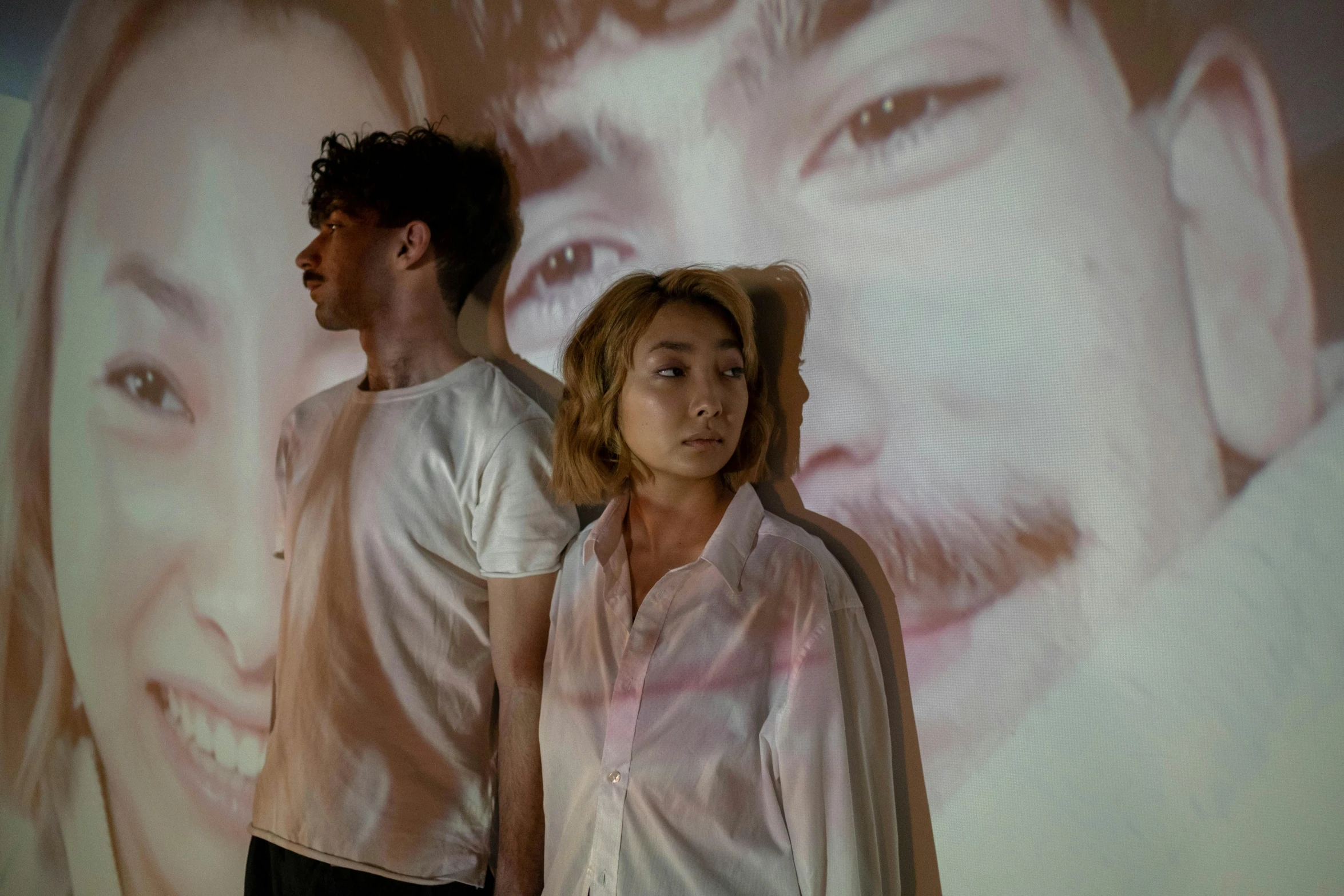 a man and a woman standing in front of a projection, a portrait, unsplash, gutai group, imogen poots d&d paladin, taejune kim, liam brazier and nielly, ( ( theatrical ) )