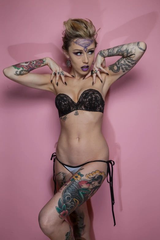 a woman with tattoos posing for a picture, inspired by Jessie Alexandra Dick, tiny black bra, full product shot, drag, uncropped