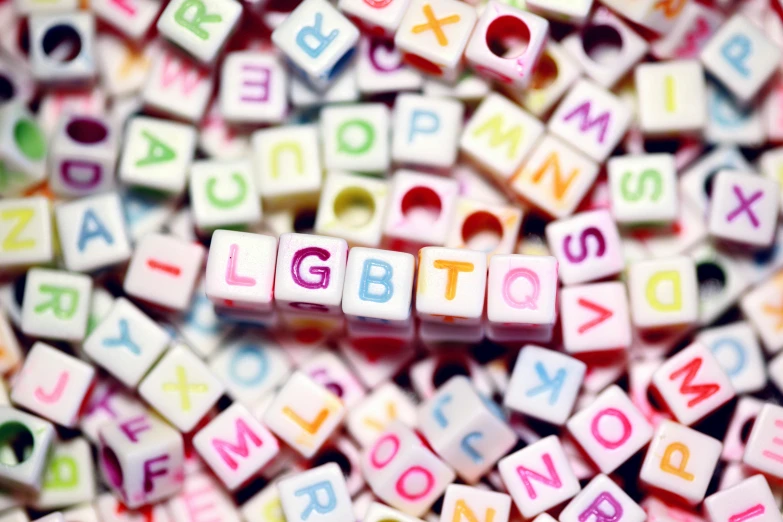 a pile of letters sitting on top of a table, by Helen Berman, shutterstock, graffiti, lgbt flag, lego, squares, lesbians