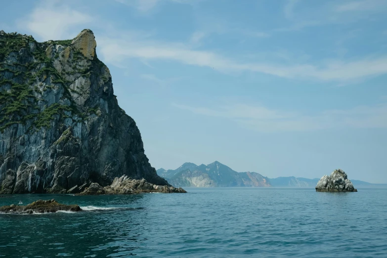 a rock formation in the middle of a body of water, by Jang Seung-eop, unsplash contest winner, romanticism, view from the sea, south korea, slide show, 4k movie still
