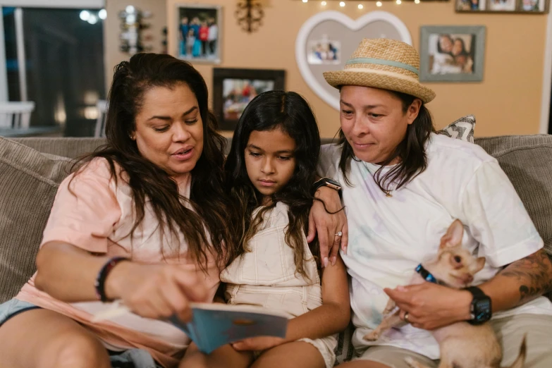 a group of people sitting on top of a couch, a portrait, pexels, portrait of family of three, hispanic, lesbian, using a magical tablet