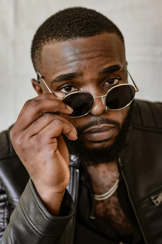 a man in a leather jacket talking on a cell phone, an album cover, trending on pexels, jaylen brown, wearing shades, headshot profile picture, liam