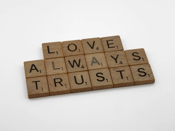a scrabble that says love always trusts, by Sylvia Wishart, letterism, wood effect, mini, bricks, official product photo
