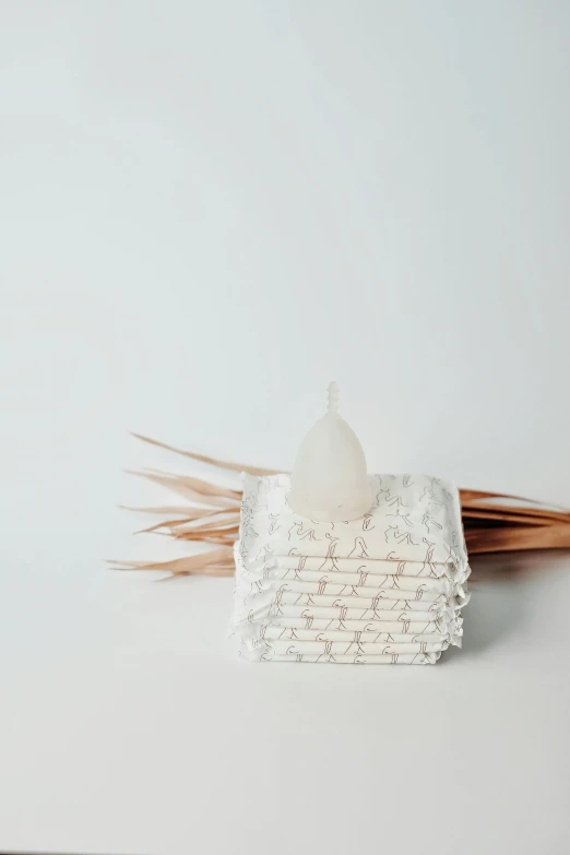 a white candle sitting on top of a white table, overflowing with diapers, in a white boho style studio, made of lab tissue, 1 / 1 2 5