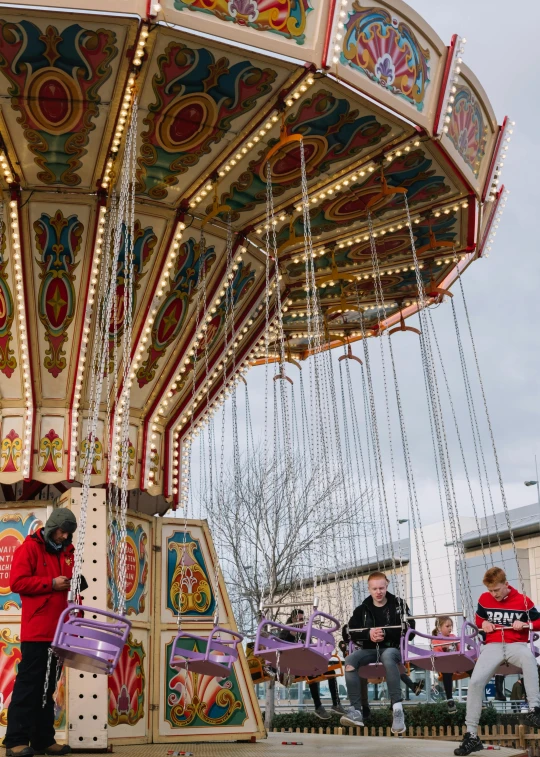 a group of people riding on top of a carousel, paisley, discovery zone, profile image, street photo