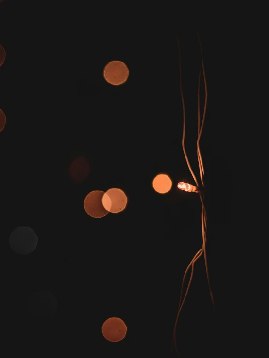 a couple of lights that are in the dark, a picture, unsplash, light and space, wires and strings, trending photo, bokeh photo, atmospheric lighting - n 9