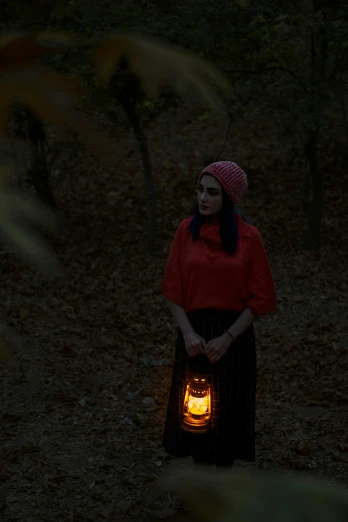 a woman standing in the woods holding a lantern, pexels contest winner, romanticism, halloween scene, portrait mode photo, sad lighting, promo image