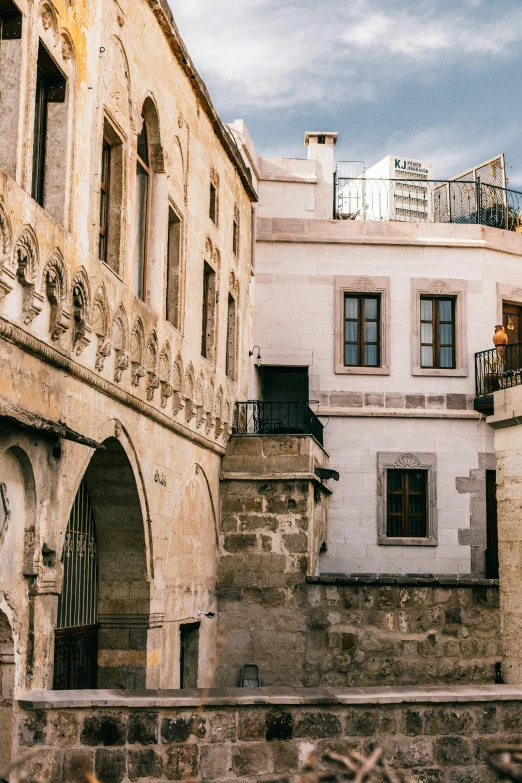 a couple of buildings that are next to each other, inspired by Osman Hamdi Bey, pexels contest winner, art nouveau, white travertine terraces, big arches in the back, exterior, conversano