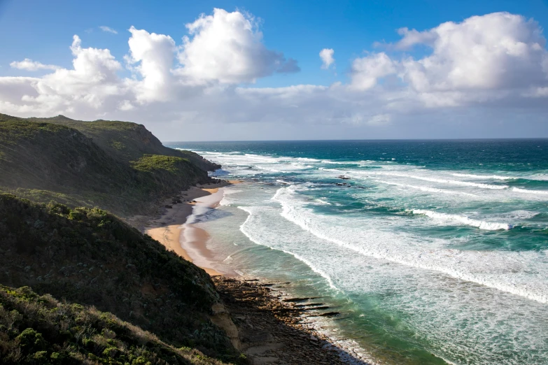 a view of the ocean from the top of a hill, by Peter Churcher, pexels contest winner, flowing cape, australian beach, slightly pixelated, curls