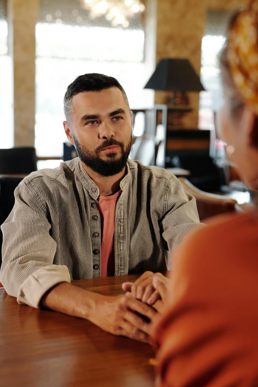 a man sitting at a table talking to a woman, a portrait, trending on pexels, hurufiyya, lgbtq, promo still, artem, hq ”