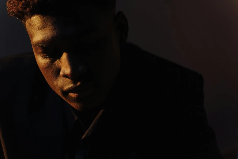 a close up of a person in a dark room, an album cover, gallant, late afternoon lighting, ignant, black teenage boy