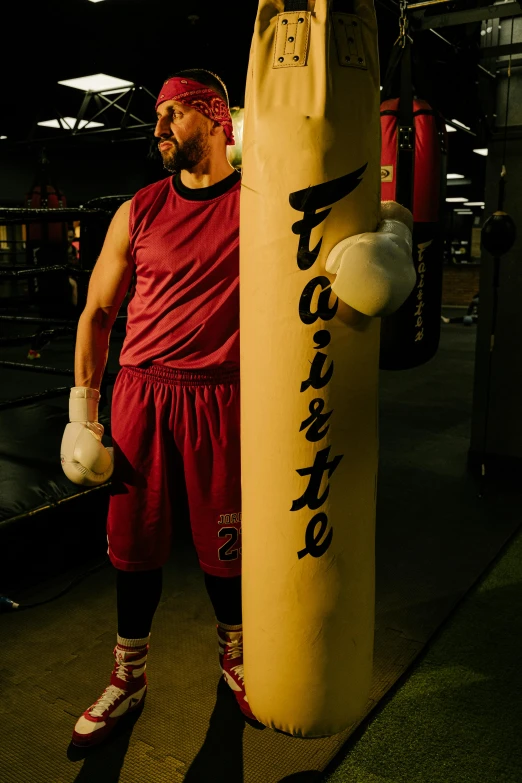 a man standing next to a punching bag, inspired by Manuel Ortiz de Zarate, happening, fate, promo image, f/4.5, faithful